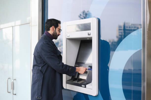 Image of a man withdrawing money from a cashpoint. Millions of  Lloyds customers to be charged 10% more for their overdraft. Find out what to do if you're affected
