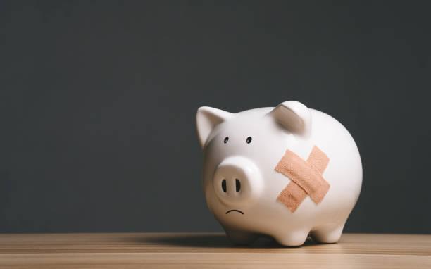 Image of a sad looking piggy bank. Nearly half of Brits dip into savings to cover everyday costs