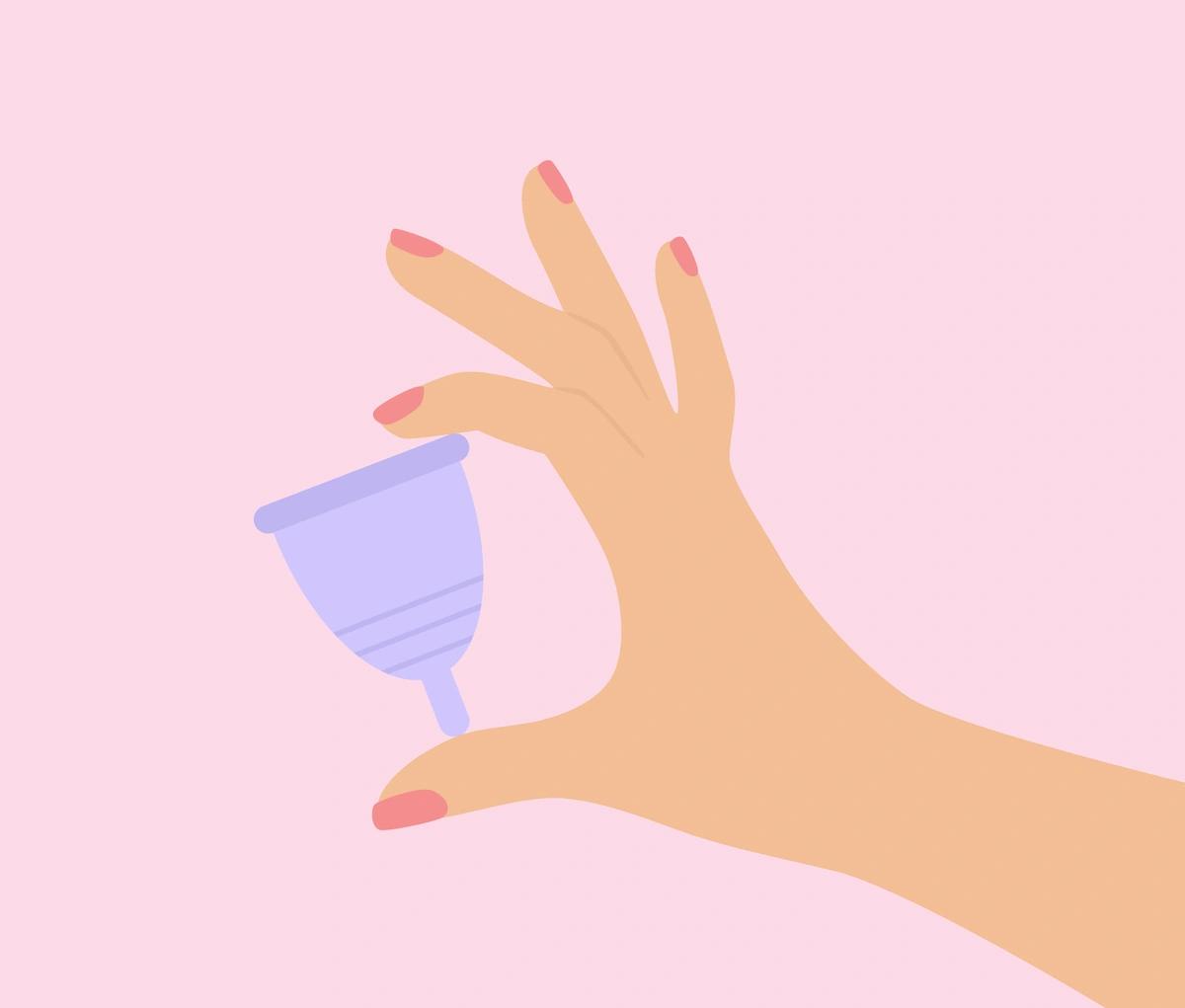 An image of a woman's hand holding a purple menstrual cup.