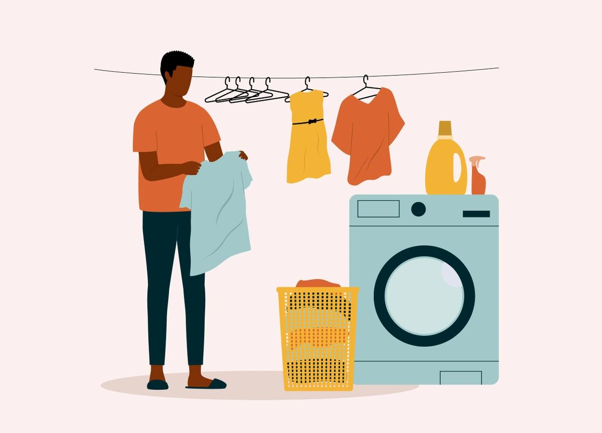 An illustration of a man getting ready to hang a clean t-shirt up with other clean clothes, next to a laundry basket of dirty clothes and a washing machine.