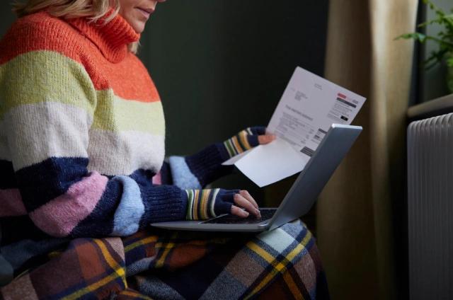 person with bills and laptop