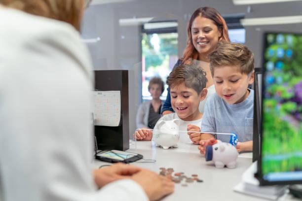Image of kids counting out money in a bank with their parent behind. Top tips to teach your kids about money management