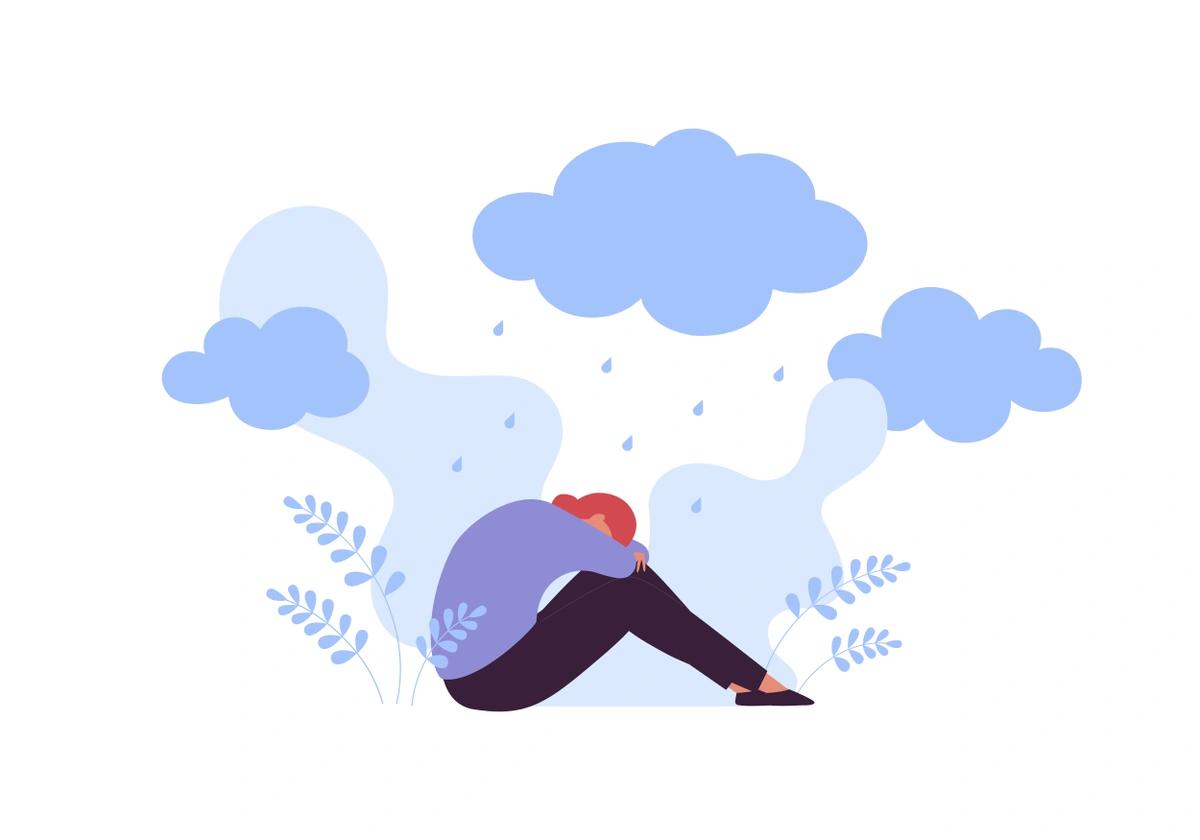 An illustration of a young woman sitting on the floor with her face buried in her arms and her knees pulled up. Three rainclouds sit above her, symbolising financial difficulty.