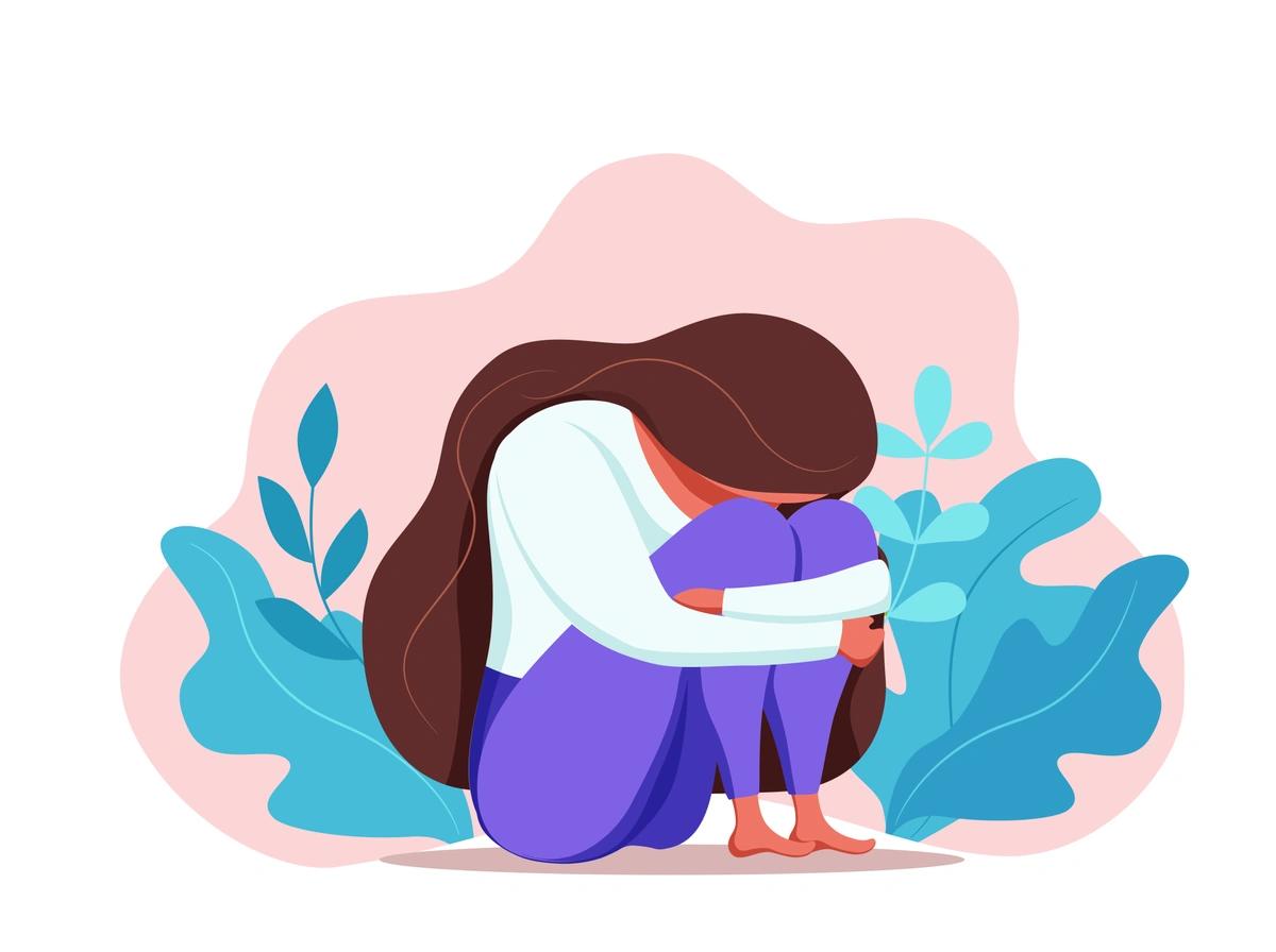 An illustration of a sad young woman sitting with her head down as she hugs her knees.