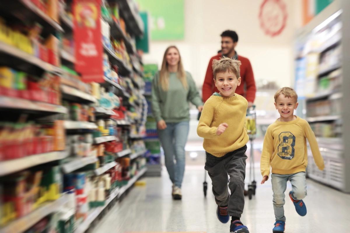 A family with two little boys shopping in the supermarket.