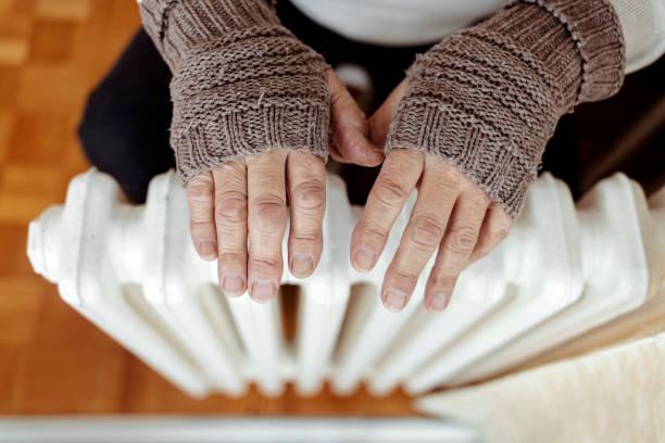 Image of someone warming their hands on a radiator. The government is encouraging pensioners to see if they’re eligible for pension credit so that they can secure a winter fuel payment