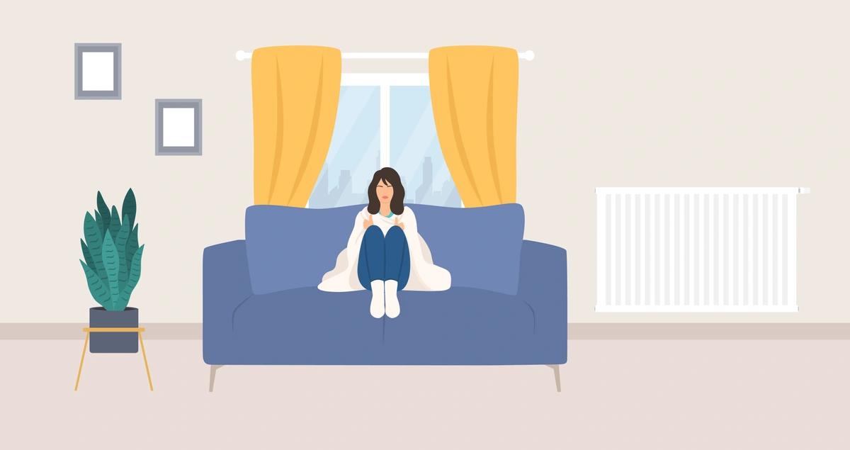 An illustration of a woman sitting on a sofa with a blanket around her shoulders.