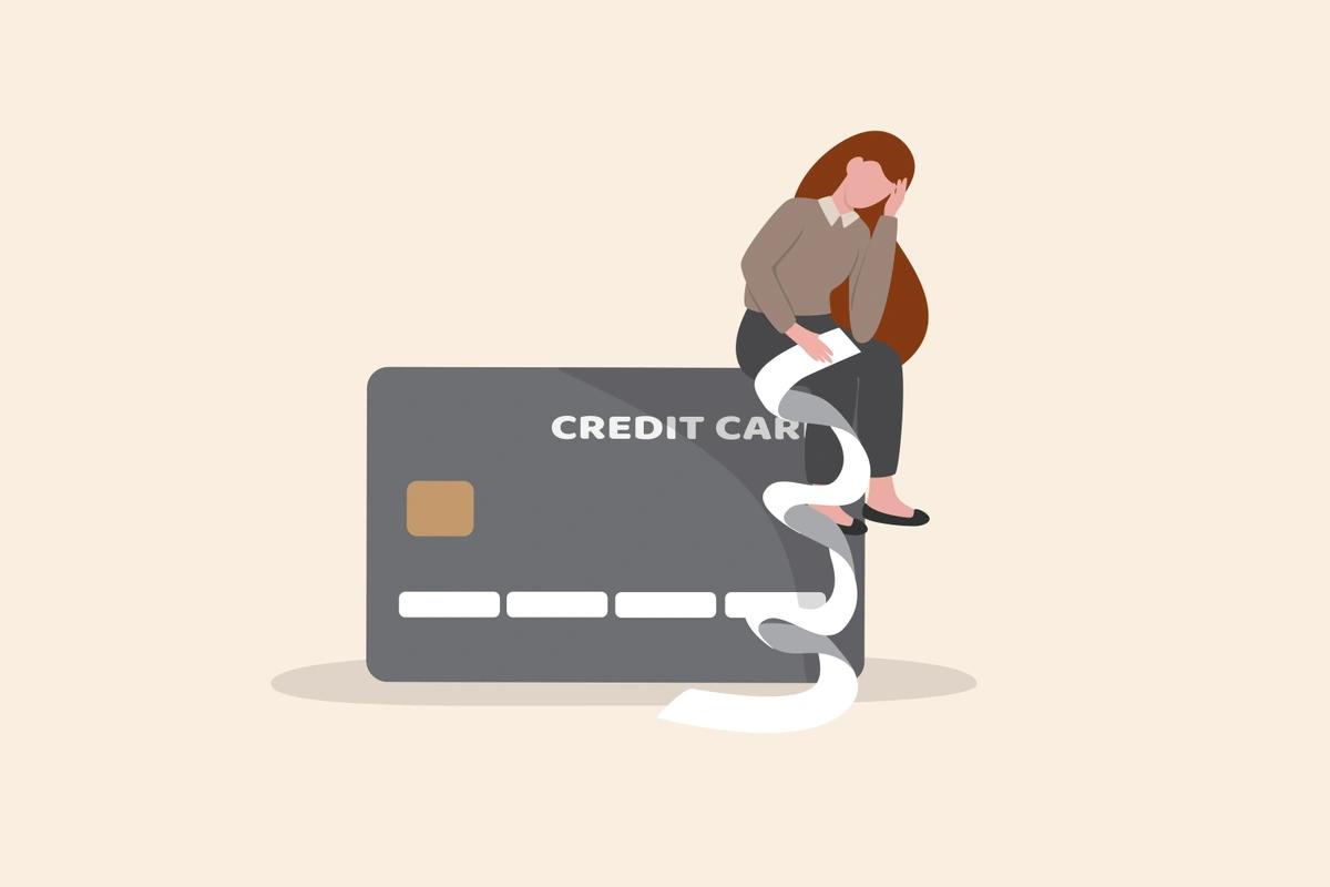 An illustration of a sad young woman sitting on a credit card with a long bill in her hand.