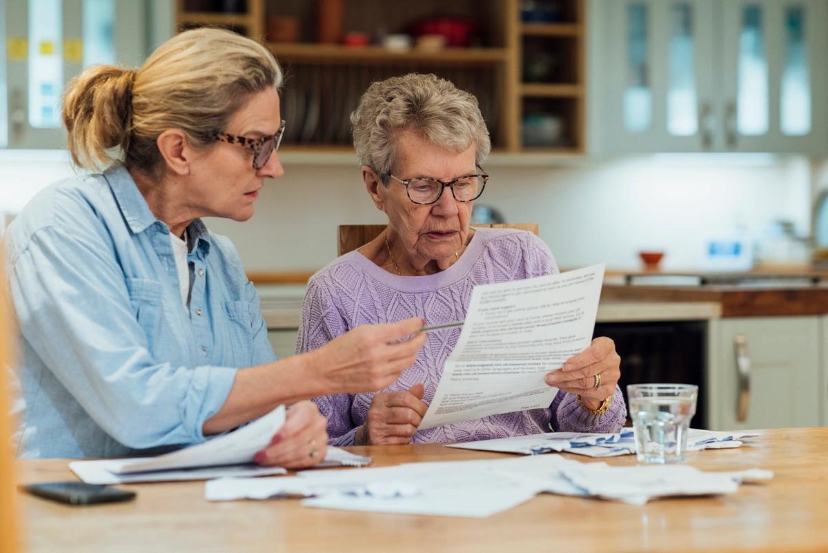 elderly lady being shown bills