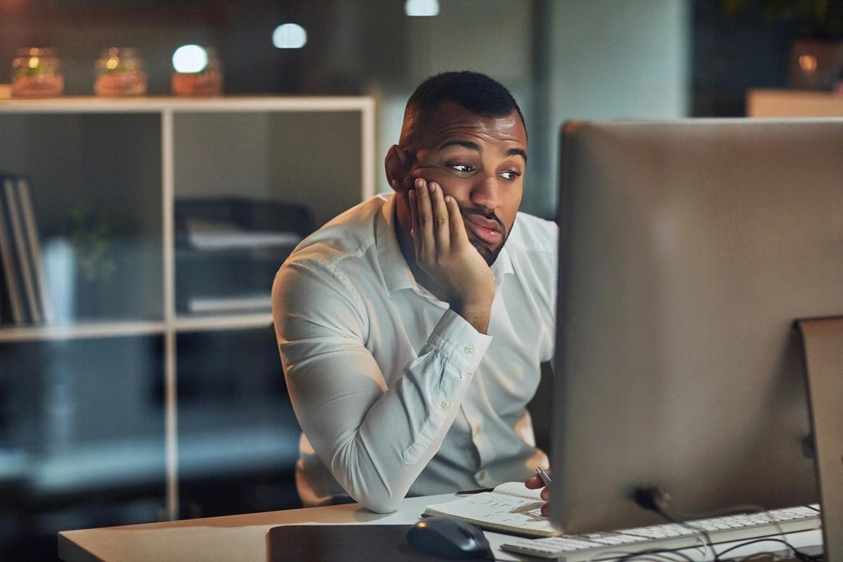 A fed-up man stares at his computer screen unable to access online banking