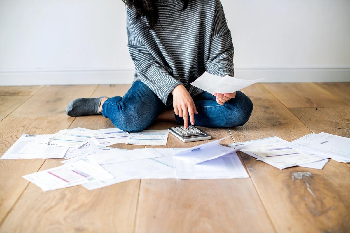 Image of someone surrounded by bills. Five million households have missed a council tax payment. Find out what to do if you have council tax debt