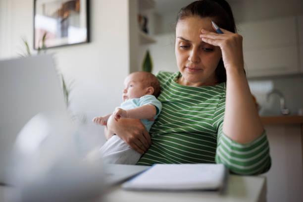 Image of a mum with a baby looking worried about bills on her laptop. 500,000 parents didn't receive their child benefit payment today. Missing child benefit payment - find out when it'll be paid. Compensation for missing child benefit payment